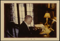 Dr. Church sitting at desk with lamp