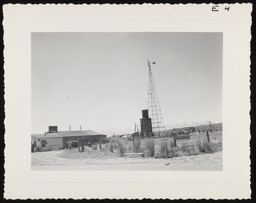 Windmill next to building in desert valley, copy 2