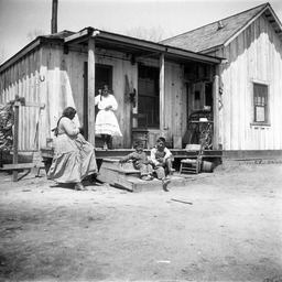 Woman and children on porch of house