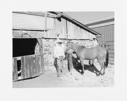 Ranch Hand John Wilker with Rowdy in front of horse barn, Walti Ranch, Eureka