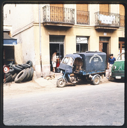 Van-like vehicle in front of old building