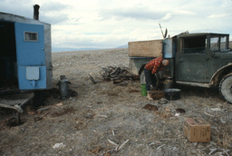 Sheepherder beside truck in camp