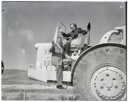 Peavine Damsite dedication, Bud Baker and Alan Bible waving from atop earthmover