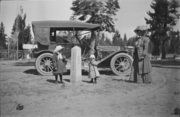 Woman and two children with a 1911 Abbott-Detroit automobile at California State Line marker