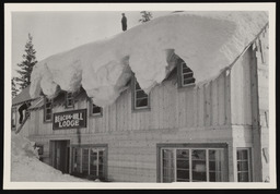 Beacon-Hill Lodge covered with snow, man on roof