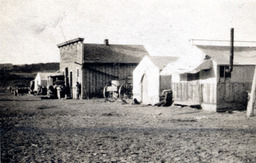 Tent house, building with false front, wagon parked between buildings
