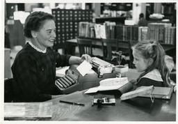 Librarian helping little girl