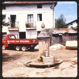 Stone water station and red work truck