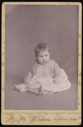 Unidentified baby wearing a dress