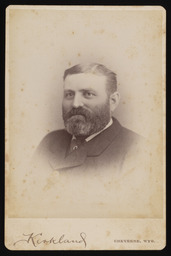 Unidentified man with a square face and full beard