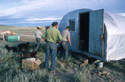 Herders preparing to move camp and camp wagon