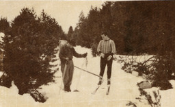 Two men, one possibly James Edward Church, on skis with survey equipment