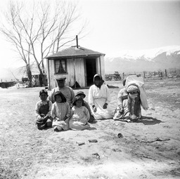 Paiute family in front of house