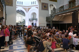 Attendees watching Opening Ceremony in Smithsonian Arts Building