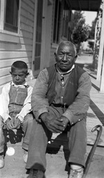 Paiute man and boy sitting on porch
