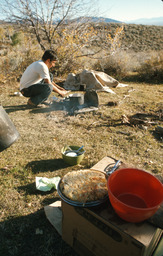 Herder preparing food over open fire
