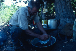 Herder washing kitchen pot in washtub