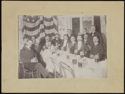 Group photo of men in room with beer steins
