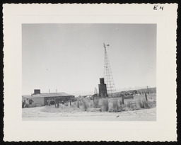 Windmill next to building in desert valley, copy 1
