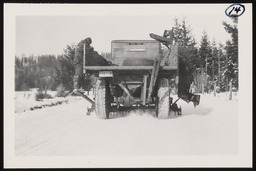 Workers riding on snow removal vehicle