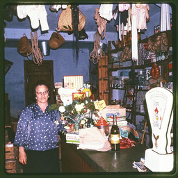 Woman standing at store counter with items on it