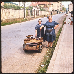 Two women standing next to cart