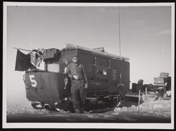 Carl leaning on armored vehicle