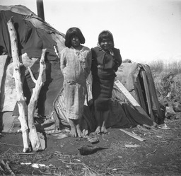 Young Indian girls beside wickiup