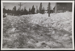 Ripple marks on sand covered snow with building in background, copy 1