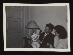 Leland Sparks Jr. holding a baby and sitting next to Patricia
