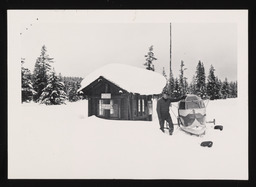 Man posing with Sno-plane outside Yellowstone shed