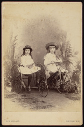 Two girls on tricycles