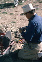 Herder working with whetstone and shearing tools