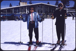 Two children in front of Squaw Valley lodge with Olympic logo rings on it