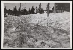 Ripple marks on sand covered snow with building in background, copy 5