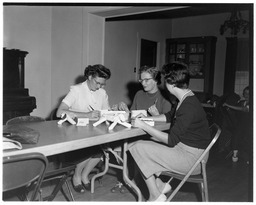 Women inventorying objects at a table