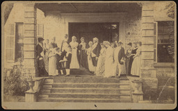 Group of people standing on the front porch of a building