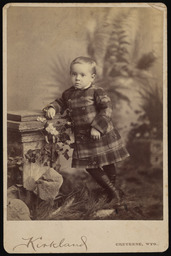 Unidentified boy wearing a plaid jacket and skirt