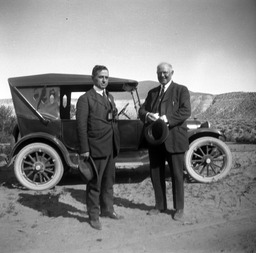 Two men in front of an automobile at Pyramid Lake