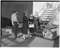 Mrs. Winifred Newport bidding farewell to Mrs. Elva K. Smith and Mrs. Beulah Maytnier at bottom of airplane stairs