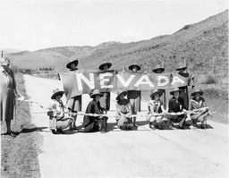 Women on a road holding a "Nevada" banner, circa 1925