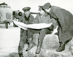 Capt. D. L. Sayle, Chief L. K. Vaughn, and Flight Lt. Peter E. Berry study a map during Operation Haylift