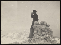 Man with binoculars at mountain summit, copy 1