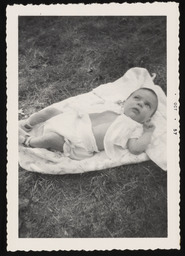 Emily Church as a baby lying in grass