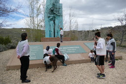 Participants at monument, one holding the baton with the message