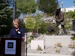 Debra Moddelmog speaking in front of statue