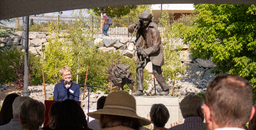 Debra Moddelmog speaking in front of statue