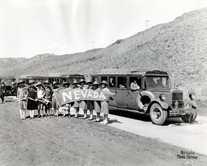 Women standing in front of Nevada-California buses with a "Nevada" banner, circa 1925
