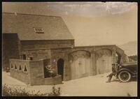 Man sitting on a car outside of Maud Sparks MacKenzie's mansion