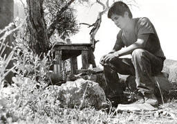 Man sitting on a rock at camp